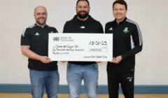 Three men holding a large check for £1,400 made out to Children with Cancer UK from Lanark Celtic Football Club.