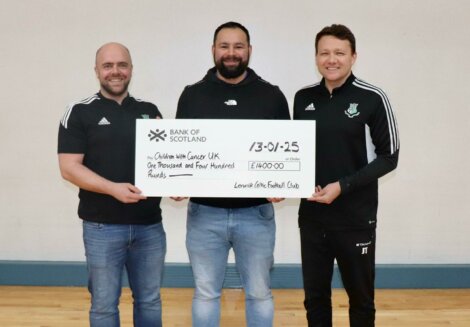Three men holding a large check for £1,400 made out to Children with Cancer UK from Lanark Celtic Football Club.