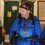 Three people wearing outdoor gear and headlamps talk indoors, preparing for an activity.
