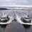 Two boats navigate parallel paths on a calm body of water with snow-covered land in the background, leaving symmetrical wakes behind them.
