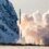 A rocket launches vertically into the sky, leaving a trail of smoke, with snow-covered mountains and ground in the background.