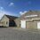 A plain, brown industrial building with a sign reading "Shetland Global Seafood Ltd" under a blue sky with scattered clouds.