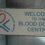 Sign reads “Welcome to the Blood Donor Centre” with the Scottish National Blood Transfusion Service logo, featuring a heart and blue cross.