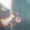 A person in an orange suit is being hoisted from the ocean into a helicopter via a rescue basket.
