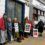 A group of people stand outside a building holding signs with messages calling for a ceasefire and opposing genocide in Gaza.