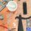 A variety of jewelry-making tools and materials, including wire mesh, pliers, stencils, a mortar and pestle, and metal components, are arranged on a work surface.