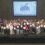 A large group of people on stage hold certificates at the Saltire Awards Ceremony 2025, with a presentation screen and banners in the background.