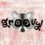 A raccoon’s face is illustrated with the word “groovy!” forming its eyes and surrounding it, set against a textured pink background.