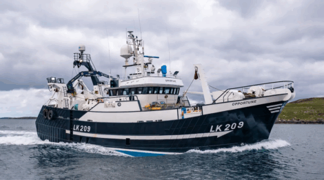 A large fishing vessel named "Opportune" with identification LK 209 sails on the water under a cloudy sky, with land visible in the background.