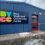 Blue building with a sign that reads “BYCC Brae Youth and Community Centre” and a red door.