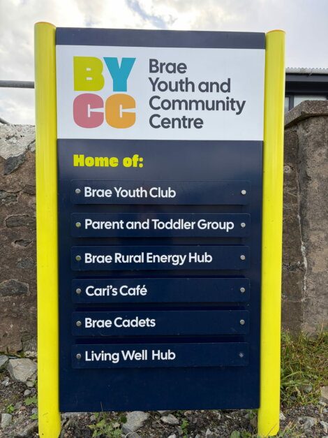 Sign for the Brae Youth and Community Centre, listing the Brae Youth Club, Parent and Toddler Group, Brae Rural Energy Hub, Cari’s Café, Brae Cadets, and Living Well Hub.